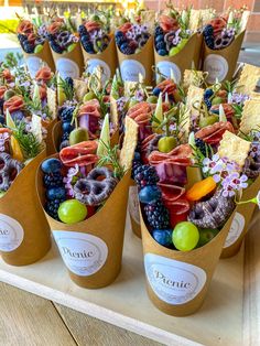 an assortment of fruits and vegetables in paper cups