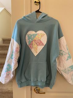 a blue hoodie with a heart on it hanging from a door handle next to some stairs