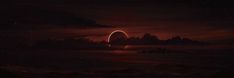 a red and black sky with some clouds and a large object in the middle of it