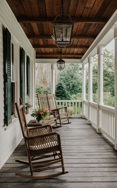 two rocking chairs on the front porch of a house