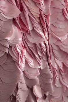 the pink wall is made up of large, wavy pieces of paper that have been folded together