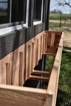 the side of a house with windows and wooden slats on it's sides