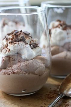 there are three desserts in glass cups on the table