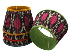 two lampshades with different patterns on them, one green and the other pink