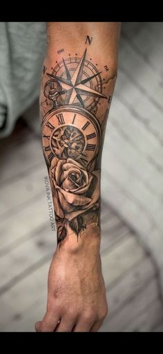 a man's arm with a compass and rose tattoo on it