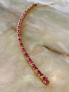 This 18K yellow gold tennis bracelet features 9.24CTW Oval Pink Spinel stones, and 1.14CTW of round white diamonds. Measures 7" in length. Luxury Pink Gold Bracelets As A Gift, Luxury Pink Diamond Bracelet For Anniversary, Luxury Oval Tennis Bracelet With Single Cut Diamonds, Oval Yellow Gold Bracelet With Single Cut Diamonds, Luxury Pink Diamond Bracelet, Formal Pink Bracelets With Diamond Accents, Luxury Diamond Tennis Bracelet With Gemstones, Luxury Pink Diamond Bracelet With Accents, Pink Diamond Gemstone Bracelets