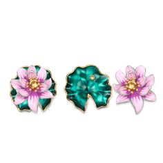 three pink and green flower brooches sitting on top of each other