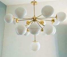 a chandelier hanging from the ceiling in a room with white walls and flooring