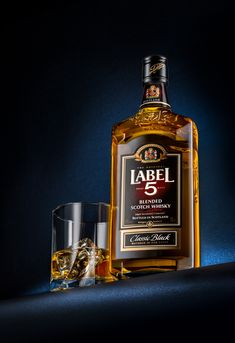 a bottle of label 5 with two glasses next to it on a dark background,