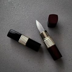 a knife and some lipstick on a table