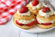 strawberry shortcakes with whipped cream and strawberries on a plate next to a fork