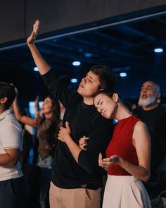 two people hugging each other while standing in front of an audience at a dance event