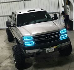 the truck is parked in the garage with its lights on and it's hood up