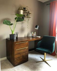 a desk with a chair and potted plant on it in front of a window