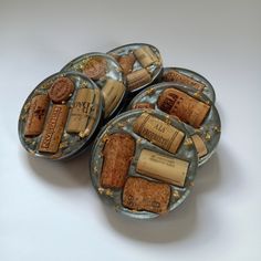 four wine corks sitting on top of each other in glass dishes with gold flecks