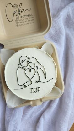 a cake in a box with a drawing of a woman holding a heart on it