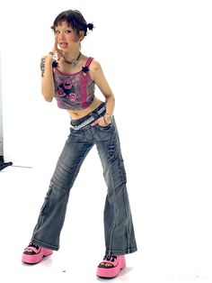 a woman in jeans and pink shoes posing for the camera with her hands on her hips