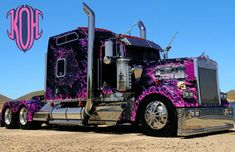 a purple and black semi truck parked in the desert