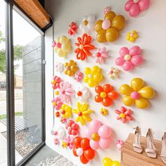 the wall is decorated with balloons and flowers