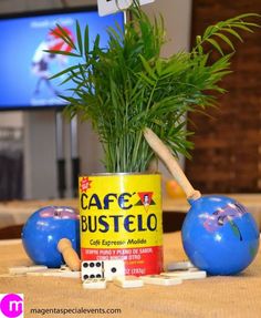 a potted plant sitting on top of a table next to two blue balls and dominos