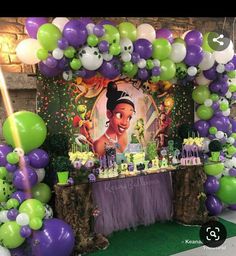 a table topped with balloons and cake next to a sign that reads,'the princess and the frog '