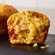 two muffins sitting on top of a black cutting board next to each other