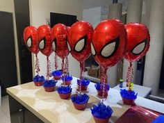 spider - man balloons and cupcakes on a table