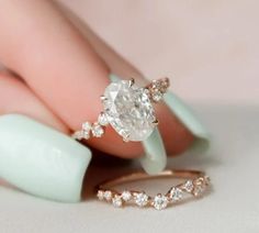 a woman's hand holding an engagement ring with a diamond on it and two diamonds in the middle