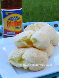 three biscuits on a white plate next to a bottle of beer and blue polka dot tablecloth