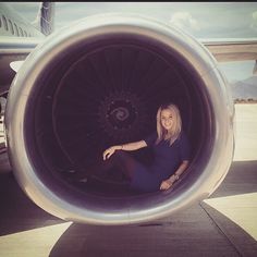 a woman sitting in the middle of an airplane engine