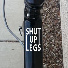 a black water bottle with the words faster damn it on it's side next to a sidewalk