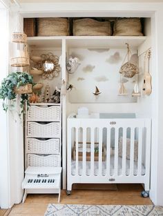 a baby's room with white furniture and baskets on the shelves, including a crib