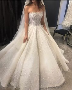 a woman wearing a wedding dress in front of a mirror