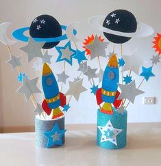 two little rockets are sitting on top of each other in the shape of stars and planets