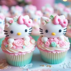 two hello kitty cupcakes sitting on top of a table