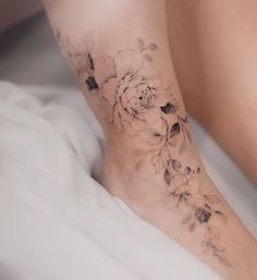 a woman's foot with flowers on it and the bottom part of her leg