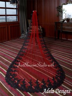 a red and black wedding veil hanging from the ceiling