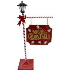 a merry christmas sign hanging from a lamp post