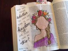 an open bible with a drawing of a woman's face and flowers in her hair