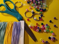 a pair of scissors sitting on top of a table next to some beads and thread