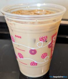 a plastic cup with donuts on it sitting on top of a counter next to a microwave