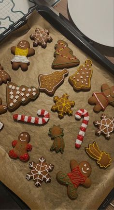 a pan filled with lots of different types of decorated cookies on top of a table