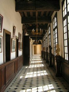 a long hallway with lots of windows and pictures on the wall