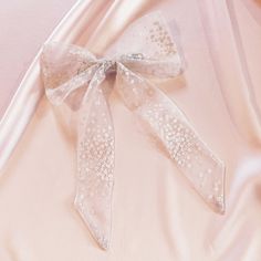 At a glance - Romantic floral tulle - Convertible bow design - Comes in a giftable drawstring bag - Ethically sewn in the UK A beautiful tulle bow with subtle floral details, perfect for large weddings and intimate ceremonies alike. Detachable ribbon tails mean you can wear your bow on its own in our Lily hair bow style, with girlier bow tails or tie the bow tail onto a hair elastic (or even your scrunchie) for a simpler pony scarf style. Adding the tails back to your hair bow is designed to be Hair Bow Style, Tulle Bow, Bow Barrette, Bow Style, Tulle Bows, Hair Elastic, Scarf Style, Silk Accessories, Bobby Pin