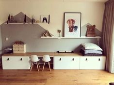 a living room with white furniture and wooden flooring next to a wall mounted art piece