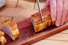 a person cutting up some food on top of a wooden board