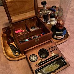 an open wooden box on top of a table filled with bottles and other items in it