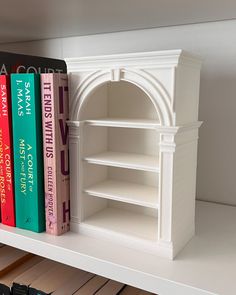 a book shelf with books on it and a clock in the corner next to it