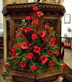 a bunch of flowers that are on top of a wooden stand in a room with other items