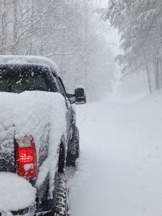 a truck covered in snow on a snowy road